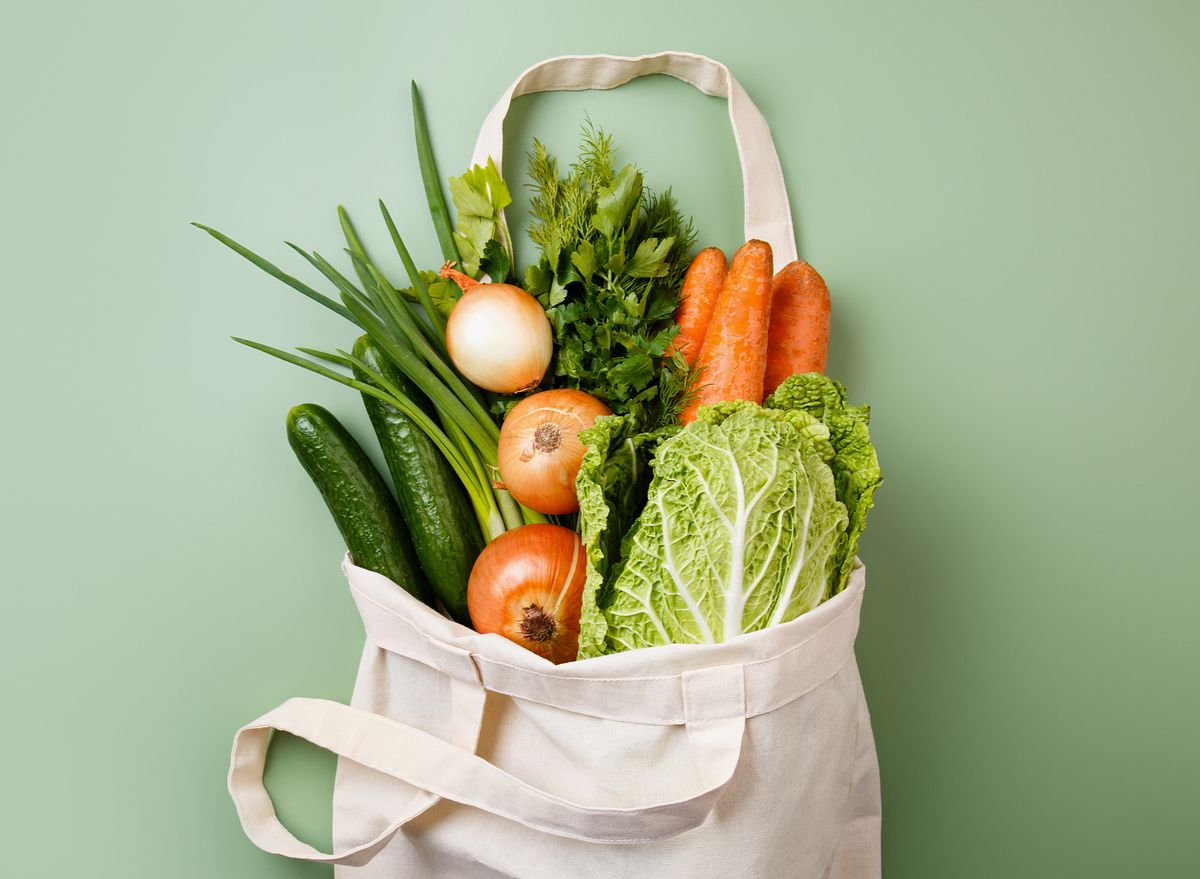 A cotton tote packed with carrots, leeks, cabbage and onions